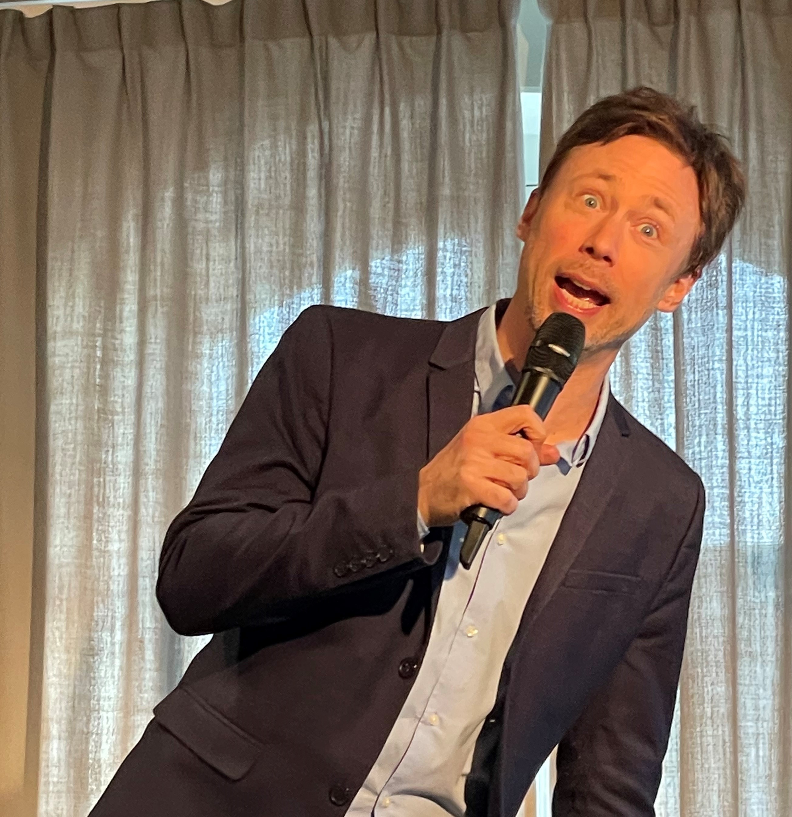 Komikern Tobias Persson håller i en mikrofon