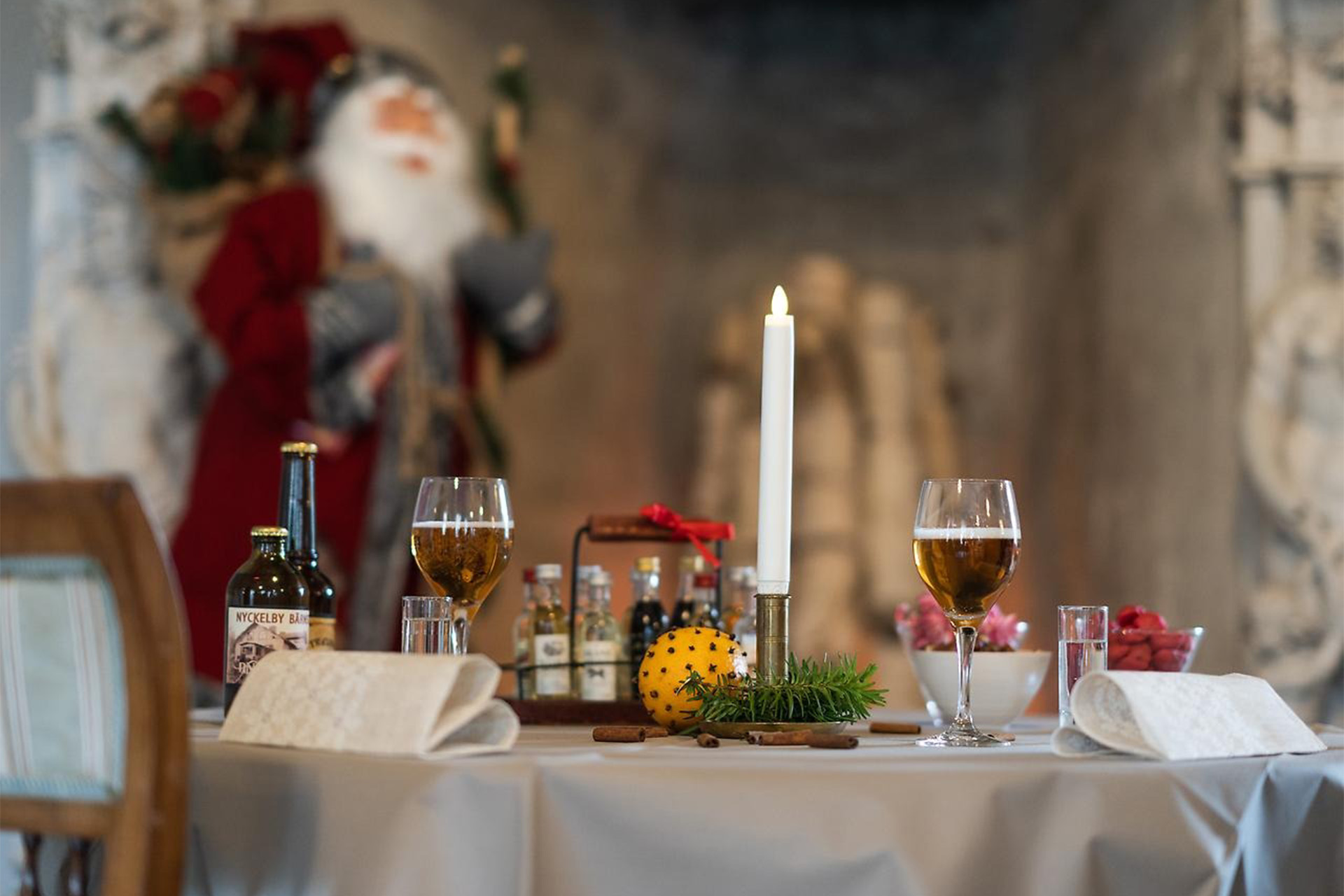 Bord dukat med levande ljus, servetter och glas med julöl