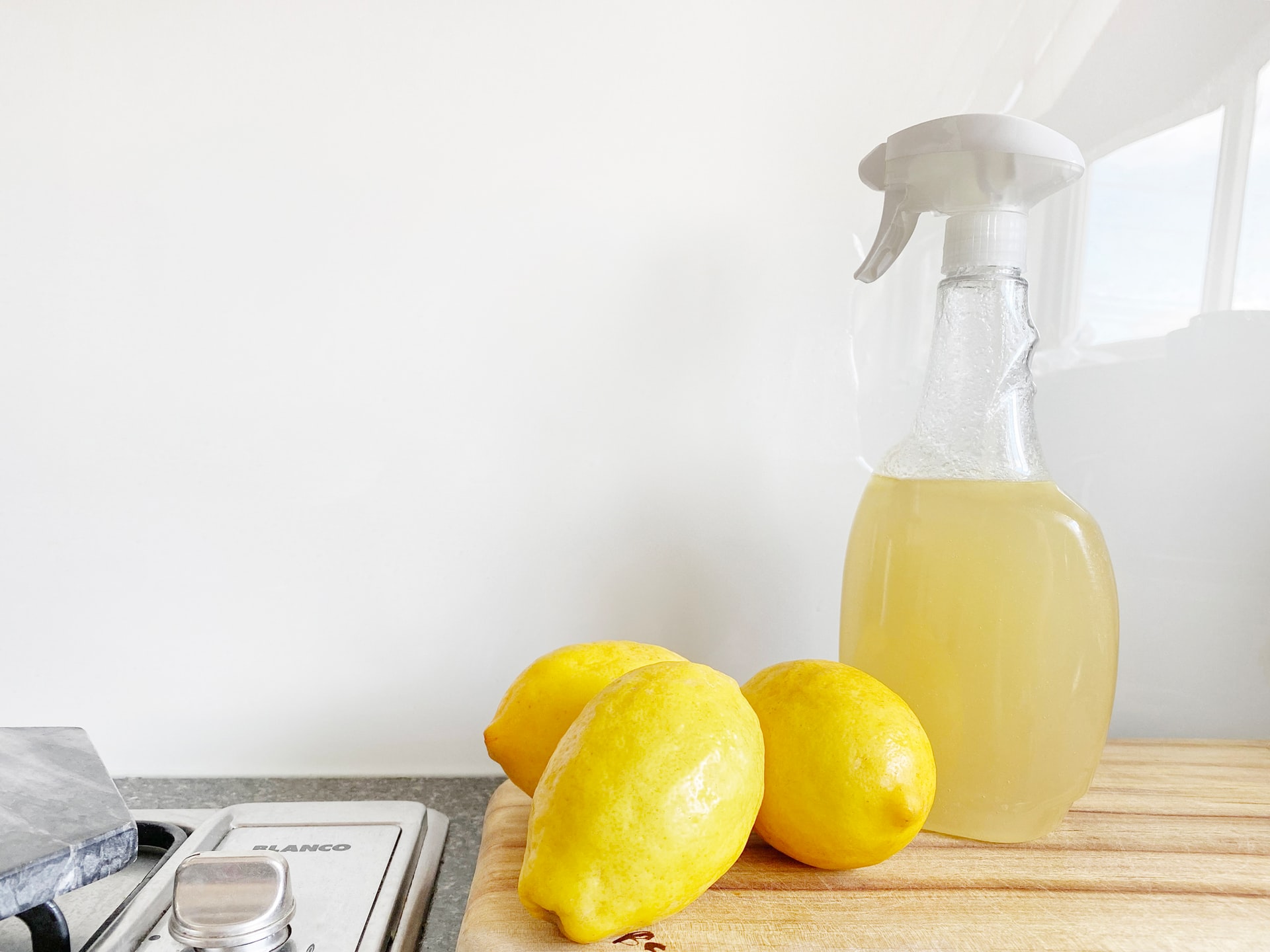 Citroner och sprayflaska på en diskbänk.