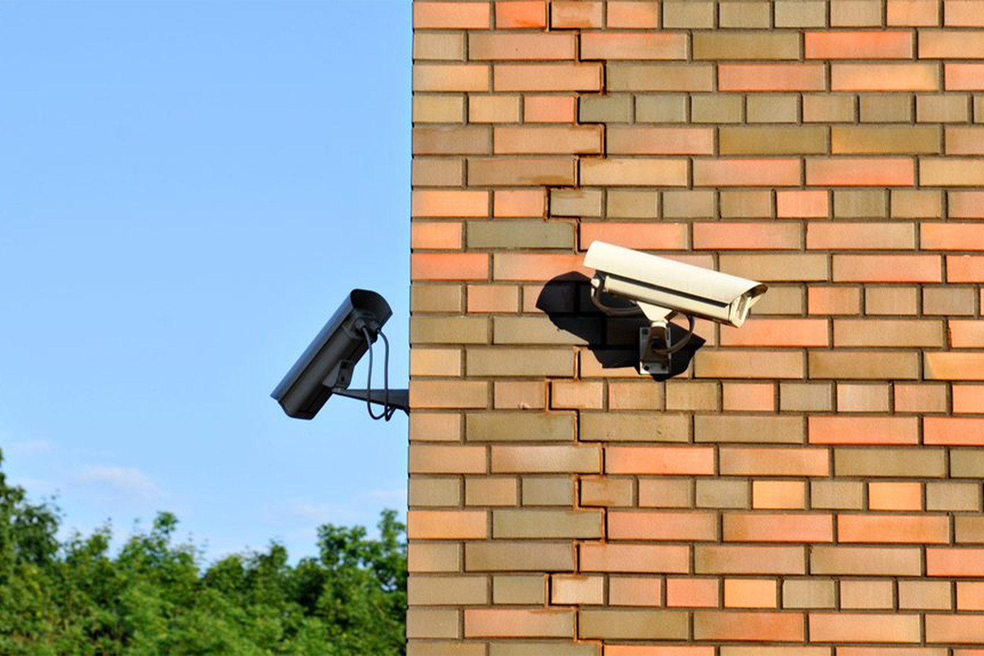 Två bevakningskameror som sitter på en vägg.
