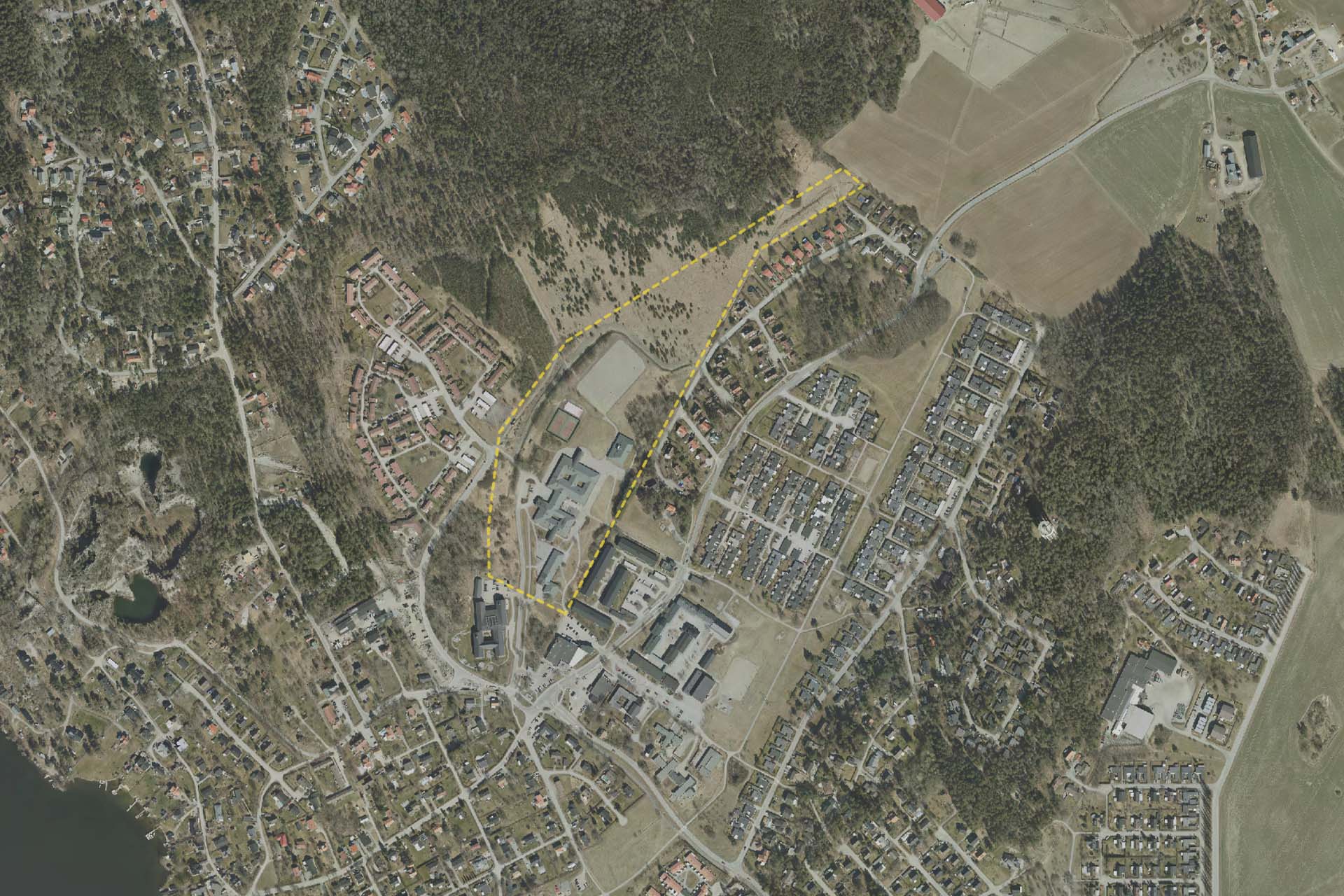 Ett flygfoto med en gul markering som visar vilket område som ska detaljplaneras