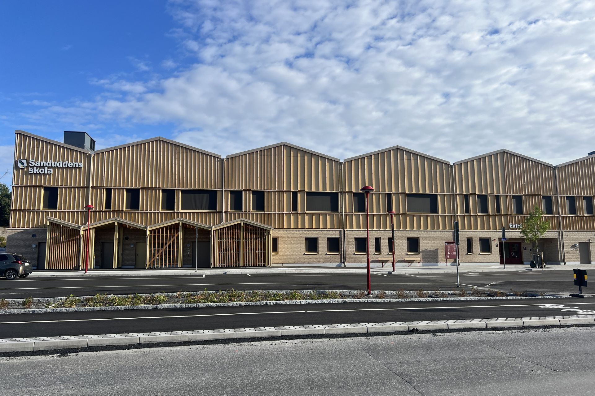 Ett stort hus i trä med tre våningar.